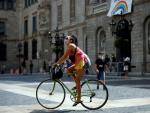 Una joven pasea con su bicleta , protegida con su mascarilla, este jueves, primer día en que es obligatorio el uso de mascarillas en toda Cataluña aunque se puedan guardar las distancias.