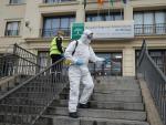 Dos efectivos de las Fuerzas Armadas realizan trabajos de desinfección ante un centro sanitario en Málaga