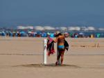 Una mujer se limpia la arena en la playa de Las Arenas de Valencia.