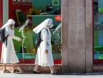 Dos monjas pasan por delante de un comercio en Zaragoza