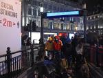 Varios ciudadanos entran en una estación de Metro en Londres, tras elevarse las restricciones