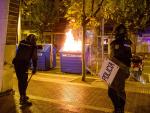 La policía, junto a un contenedor de papel ardiendo durante los nuevos incidentes registrados el domingo en Logroño.