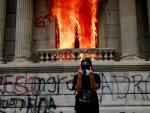 Un manifestante desafía a la policía a la puerta del Congreso en llamas de Guatemala
