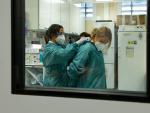 Dos sanitarios se protegen en un centro hospitalario durante la pandemia
