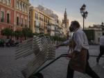 Un camarero recoge el mobiliario de la terraza de un bar de Sevilla, tras uno de los cierres de 2020
