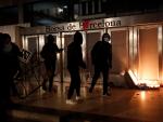 Varios manifestantes queman un contenedor en la puerta de la Bolsa de Barcelona