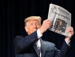 El expresidente de Estados Unidos, Donald Trump, sostiene un periódico en un acto público