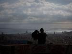 Un joven mira el paisaje en el mirador Turó de la Rovira, en Barcelona