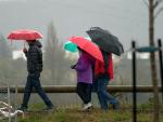 Varias personas se refugian con un paraguas de la lluvia en Vitoria, País Vasco (España)