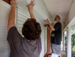 Vecinos de Luisiana colocan las contraventanas de tormenta en su casa antes de la llegada del huracán Ida.