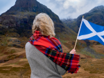 Fotografía de una escocesa con una bandera de su país.