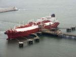 Barco metanero descargando gas en un puerto.