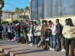 Un grupo de migrantes hacen cola en el Puerto de Ceuta para dirigirse a la península.