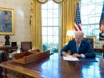 Joe Biden firma un ley en el despacho oval de la Casa Blanca.