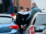 Agentes de Policía alemanes llevan esposado a uno de los detenidos en Alsdorf, cerca de Aachen (ROBERTO PFEIL / AFP)