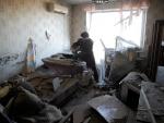 Una mujer observa los daños causados por un bombardeo en su apartamento de Donetsk