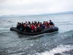Un bote abarrotado de inmigrantes afganos llega a una playa en la isla griega de Kos