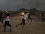 Jóvenes palestinos arrojan piedras contra las fuerzas de Israel/AFP
