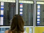 Una mujer observa los paneles de información de los vuelos en el aeropuerto de Barcelona