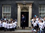 British Prime minister David Cameron (C) walks out