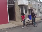 La policía empuja  y rocía con pimienta a una joven negra que se cae de una bici