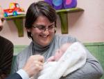 Una madre de acogida de urgencia de la Comunidad de Madrid tiene en sus brazos a un bebé dado en adopción