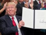 El presidente de Estados Unidos, Donald Trump, posa tras firmar una orden ejecutiva diseñada para "aliviar" a los ciudadanos ante algunos requisitos de Obamacare