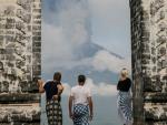 Fotografía de personas viendo el volcán Agung en erupción.