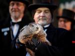 El cuidador John Grifiths (d), sostiene a la marmota Phil mientras se lee la predicción en Punxsutawney, Pensilvania (EFE/ David Maxwell)