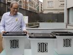 El presidente de la Generalitat, Quim Torra, sostiene la misma urna en la que depositó su papeleta el 1-O, durante su visita esta mañana a la Escuela Oficial de Idiomas de Barcelona