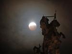 La luna llena durante la fase final del eclipse total, sobre una figura ecuestre del Apóstol Santiago en la Plaza del Obradoiro