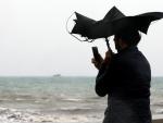 - Una persona hace una fotografía en la Playa de la Malvarrosa de Valéncia bajo la lluvia y el fuerte viento (EFE/Juan Carlos Cárdenas)