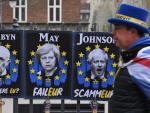 Un manifestante a favor de la estancia del Reino Unido en la Unión Europea camina junto a carteles que critican a Jeremy Corbyn (i), Theresa May y Boris Johnson en Londres. /EFE