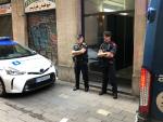 Dos agentes de la Guardia Urbana de Barcelona custodian un piso del Raval