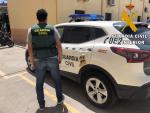 Un agentes de Guardia Civil junto a un coche en Roquetas de Mar (Almería)