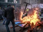 Manifestantes y 'chalecos amarillos' arrojan patinetes a una barricada en llamas durante una manifestación contra las reformas de pensiones. /EFE/EPA