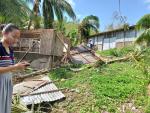 Una vecina al lado de una casa dañada en la ciudad de Balasan, provincia de Ilo-Ilo, afectada por el tifón. /EFE