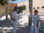 Dos sanitarios conversan en las inmediaciones del polideportivo Cortes de Aragón de Fraga, Huesca
