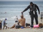 Un policía reclama información a un usuario en una playa de Florida