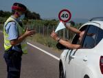 Un conductor enseña la documentación a un mosso en un control en la zona confinada de Lleida