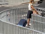 Una joven turista acarrea una maleta durante las vacaciones de 2020