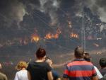 Vecinos de la localidad de Valverde del Camino observan la labores de extinción del incendio que afecta a la provincia de Huelva