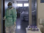 Un trabajador sanitario, en la puerta de una habitación de UCI en un hospital madrileño