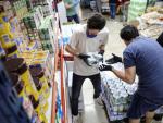 Trabajadores reponiendo productos en un supermercado