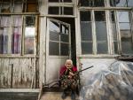 Una anciana sostiene un arma en la puerta de su casa en la localidad e Stepanakert, en pleno conflicto de Nagorno Karabaj