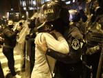 Una manifestante se abraza a una policía durante las protestas en Lima
