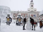 Una pareja hace un muñeco de nieve en la Puerta del Sol en Madrid
