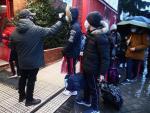 Un familiar lleva de la mano a dos alumnos del colegio Arcangel Rafael el día de la reapertura de los centros educativos tras la gran nevada registrada por el paso de ‘Filomena’, en Aluche, Madrid