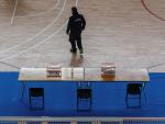 Un trabajador coloca varias urnas en una mesa electoral situada en un complejo deportivo
