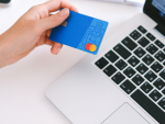 Persona pagando con su tarjeta de crédito mastercard online.